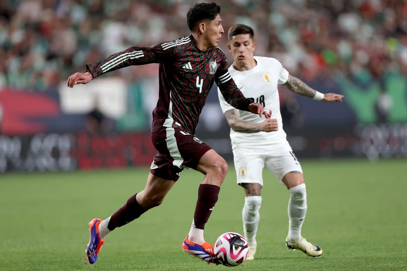 Edson Alvarez #4 of Mexico advances the ball against Paul Brian Rodriguez #18 of Uruguay in the second half during an international friendly match between Mexico and Uruguay at Empower Field At Mile High on June 05, 2024 in Denver, Colorado.