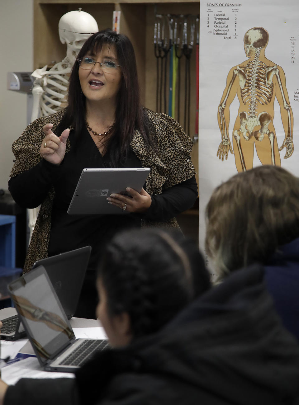 In this Wednesday, Jan. 15, 2020 photo, teacher Ruth Nall speaks to high school students in her class in Modesto, Calif. Nall participated in a study reading sentences aloud as a network of surgically implanted sensors kept close track of how her brain worked. One of her experimental tasks sounds a little strange: During her 2013 hospital stay she was asked to repeat the sentence, "I never said she stole my money" over and over, putting an emphasis on a different word each time. Those changes altered the meaning of the sentence. (AP Photo/Ben Margot)