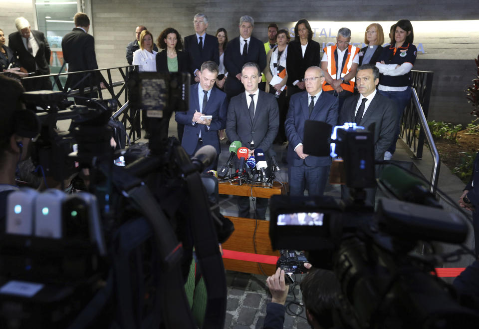 German Foreign Minister Heiko Maas, second left, Portuguese Foreign Minister Augusto Santos Silva, center, and Pedro Calado, vice president of regional government, right, address the media outside the hospital in Funchal, the capital of Portugal's Madeira Island, Thursday April 18, 2019 after visiting people injured in the bus crash. All the 29 people killed in a bus crash on Portugal's Madeira Island were German, Portugal's foreign ministry confirmed Thursday. The bus carrying 55 people, all but two of them German tourists, rolled down a steep hill after veering off the road on a bend east of Madeira's capital, Funchal, on Wednesday evening when it was still light and in fine weather. (AP Photo/Armando Franca)