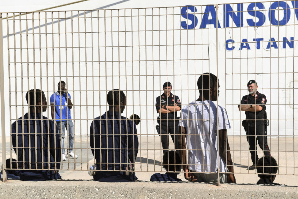 Some of migrant minors allowed to disembark the Open Arms vessel, anchored off the Sicilian vacation and fishing island of Lampedusa, southern Italy, wait to be taken to the Sicilian port of Porto Empedocle from Lampedusa, Monday, Aug. 19, 2019. The boat, which Italian Interior Minister Matteo Salvini won't let into port, initially had 147 migrants aboard when it reached Italian waters but in the last few days, 40 migrants have transferred by Italian coast guard vessels to Lampedusa, including a few who were ailing and 27 believed to be minors. (AP Photo/Salvatore Cavalli)