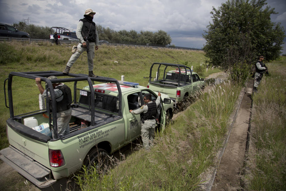 FILE - Pemex security employees inspect an illegal tap into a state-owned pipeline in a cornfield in San Bartolome Hueyapan, Tepeaca, Mexico, July 11, 2017. Despite Pemex's struggles, Mexico continues to be one of the world's biggest oil producers. (AP Photo/Eduardo Verdugo, File)