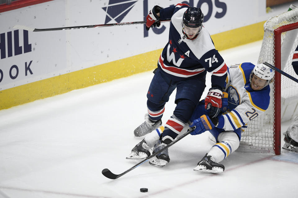 Washington Capitals defenseman John Carlson (74) and Buffalo Sabres center Cody Eakin (20) vie for the puck during the second period of an NHL hockey game Thursday, April 15, 2021, in Washington. (AP Photo/Nick Wass)