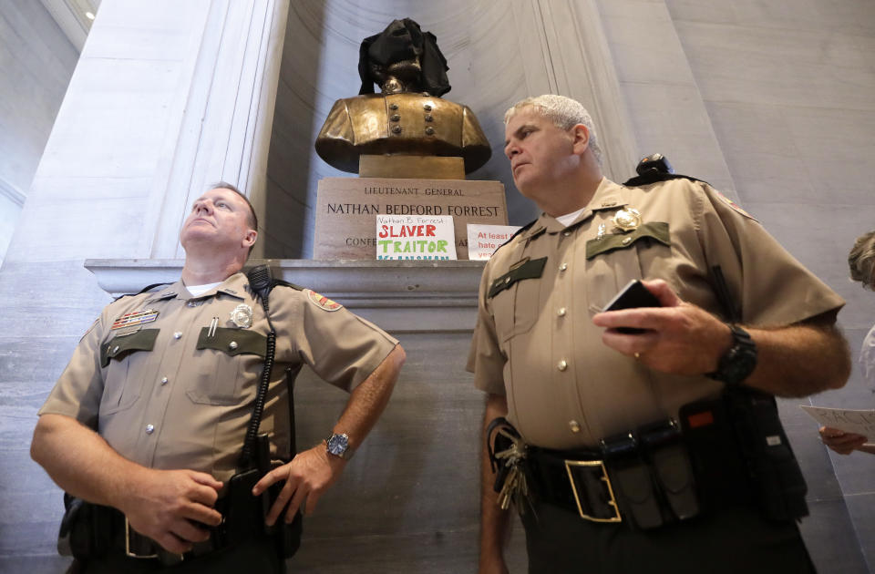 FILE - In this Aug. 14, 2017, file photo, Tennessee State Troopers stand near a bust of Confederate Gen. Nathan Bedford Forrest after protesters covered it and placed signs in front in Nashville, Tenn. Activists and Democratic lawmakers have called for the removal of a bust of Forrest from the state Capitol. (AP Photo/Mark Humphrey, File)