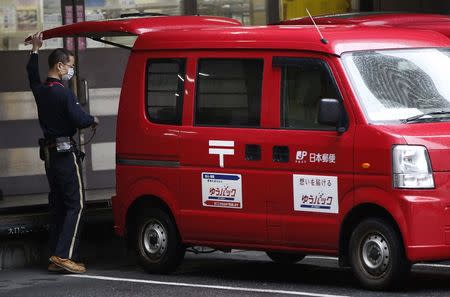 An employee of Japan Post works in Tokyo, February 18, 2015. REUTERS/Issei Kato