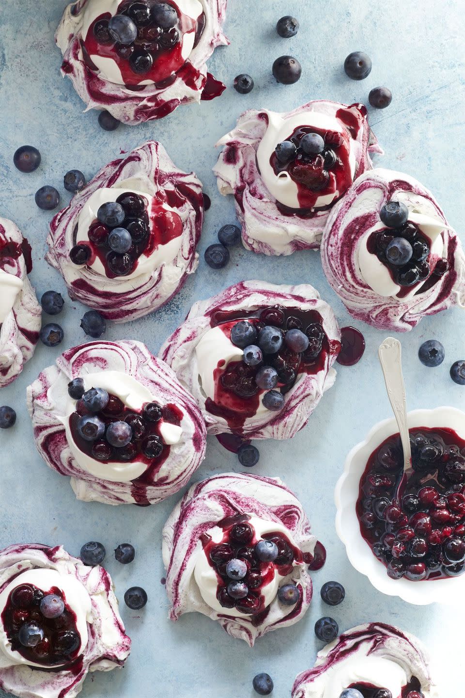 blueberry swirled meringues with whipped cream and blueberry sauce