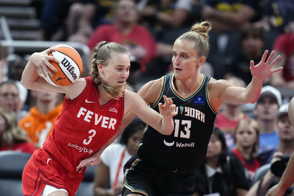 Indiana Fever's Kristy Wallace (3) goes to the basket against New York Liberty's Leonie Fiebich during the first half of a WNBA basketball game, Saturday, July 6, 2024, in Indianapolis. (AP Photo/Darron Cummings)