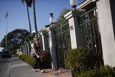 A woman leaves flowers outside the home of actor and comedian Robin Williams in Tiburon, California August 11, 2014. REUTERS/Stephen Lam