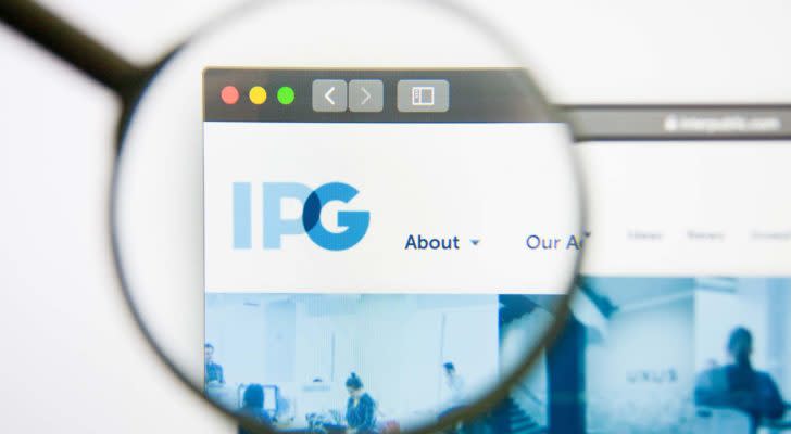 A magnifying glass zooms in on the website of the Interpublic Group of Companies (IPG).