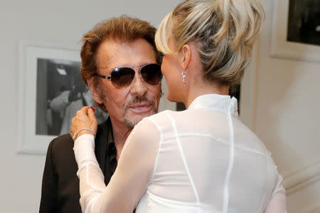 FILE PHOTO: French singer Johnny Hallyday and his wife Laeticia pose before attending the Dior Haute Couture Fall Winter 2016/2017 fashion show in Paris, France, July 4, 2016. REUTERS/Benoit Tessier/File Photo