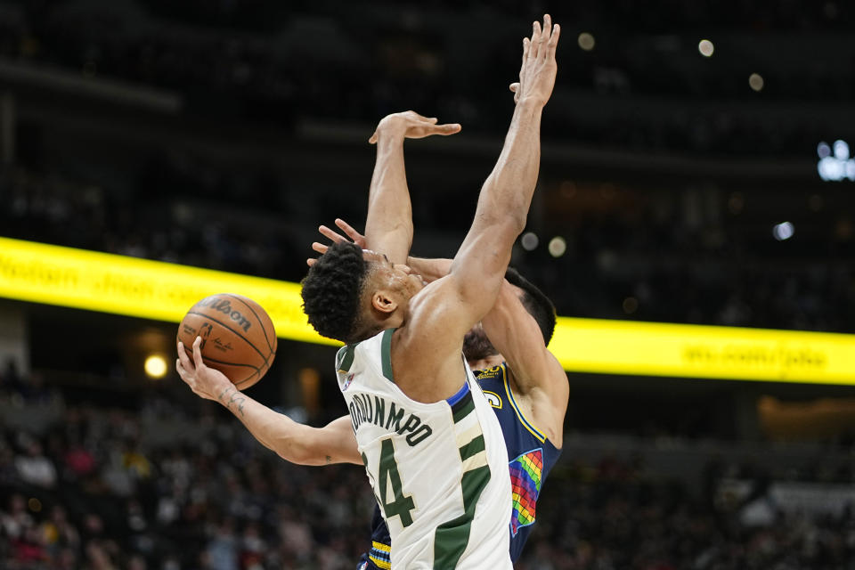 Milwaukee Bucks forward Giannis Antetokounmpo (34) collides with Denver Nuggets guard Facundo Campazzo (7) during the second quarter of an NBA basketball game Friday, Nov. 26, 2021, in Denver. (AP Photo/Jack Dempsey)