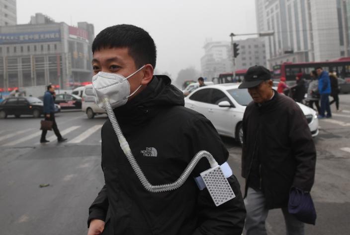 A pedestrian wears a mask on a heavily polluted day in Shijiazhuang, in northern China's Hebei province, on December 21, 2016 (AFP Photo/GREG BAKER)