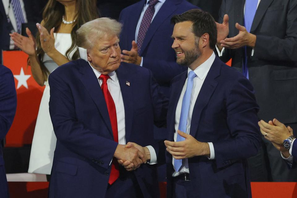 Republican presidential nominee and former U.S. President Donald Trump shakes hands with Republican vice presidential nominee J.D. Vance during Day 1 of the Republican National Convention (RNC), at the Fiserv Forum in Milwaukee, Wisconsin, U.S., July 15, 2024. REUTERS/Brian Snyder