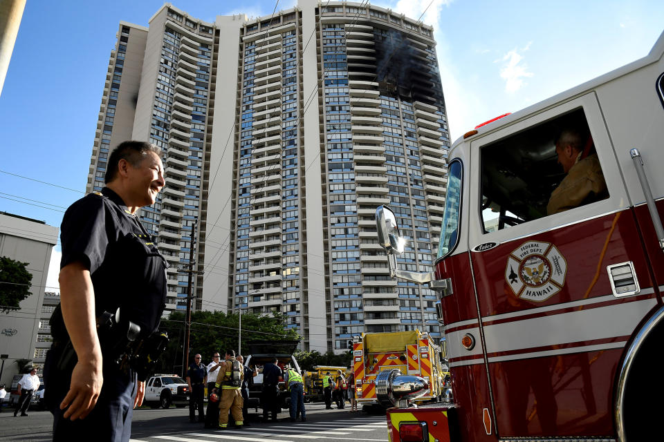 A police officer directs a fire truck