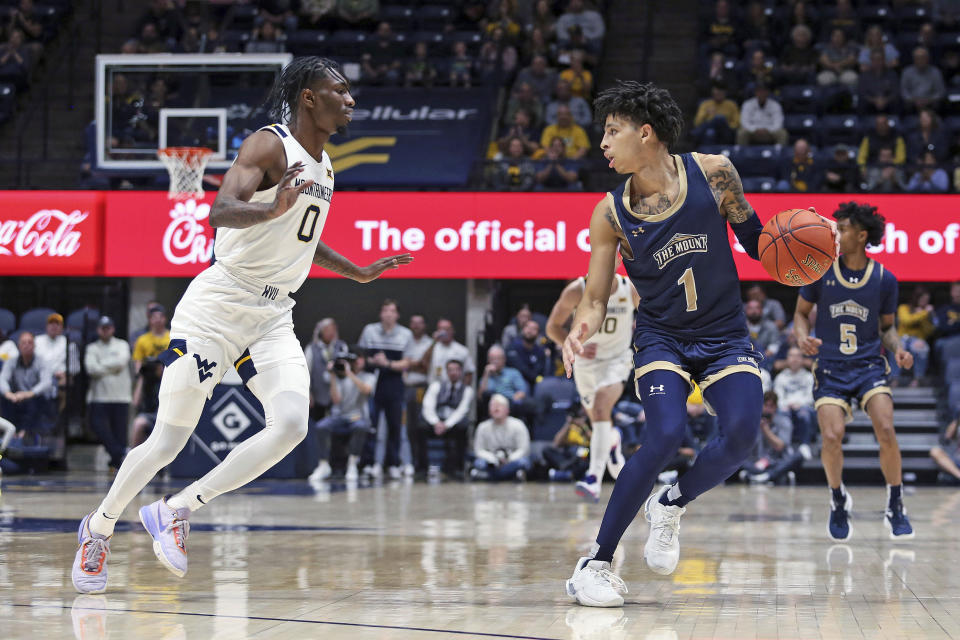 Mount St. Mary's guard Dakota Leffew (1) looks to make a move as West Virginia guard Kedrian Johnson (0) defends during the first half of an NCAA college basketball game in Morgantown, W.Va., Monday, Nov. 7, 2022. (AP Photo/Kathleen Batten)