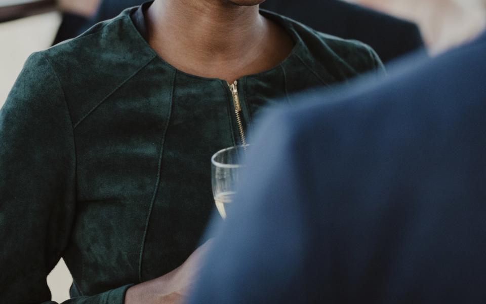 woman holding a drink while speaking with a man