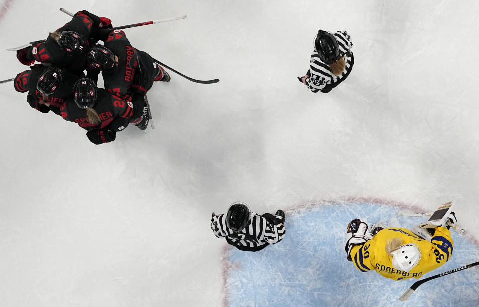 Canada's players celebrate after scoring past Sweden goalkeeper Emma Soderberg, right, during a women's quarterfinal hockey game between Sweden and Canada at the 2022 Winter Olympics, Friday, Feb. 11, 2022, in Beijing. (AP Photo/Petr David Josek)