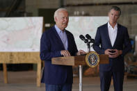 FILE - In this Sept. 13, 2021, file photo President Joe Biden speaks about recent wildfires, at Sacramento Mather Airport in Mather, Calif., as California Gov. Gavin Newsom listens. Surveying damage from California wildfires to hurricane-induced flooding in Louisiana and New York Biden said America must get serious about the “code red” danger posed by global warming. (AP Photo/Evan Vucci, File)