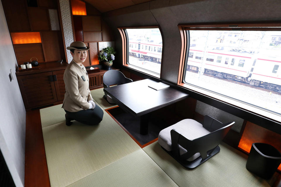 <p>A crew member kneels beside the dining set inside the Shiki-shima Suite, the top accomodation on the train, which comes at a cost of $10,000 per person for a four-day trip from Tokyo to Hokkaido. (Photo: STR/AFP/Getty Images) </p>