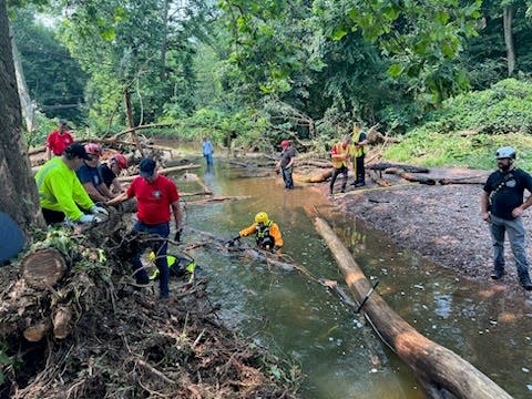 These photos taken July 17-18, 2023 show first responder volunteers digging and checking Houghs Creek by hand on in the debris fields to see which piles could be disassembled by hand.