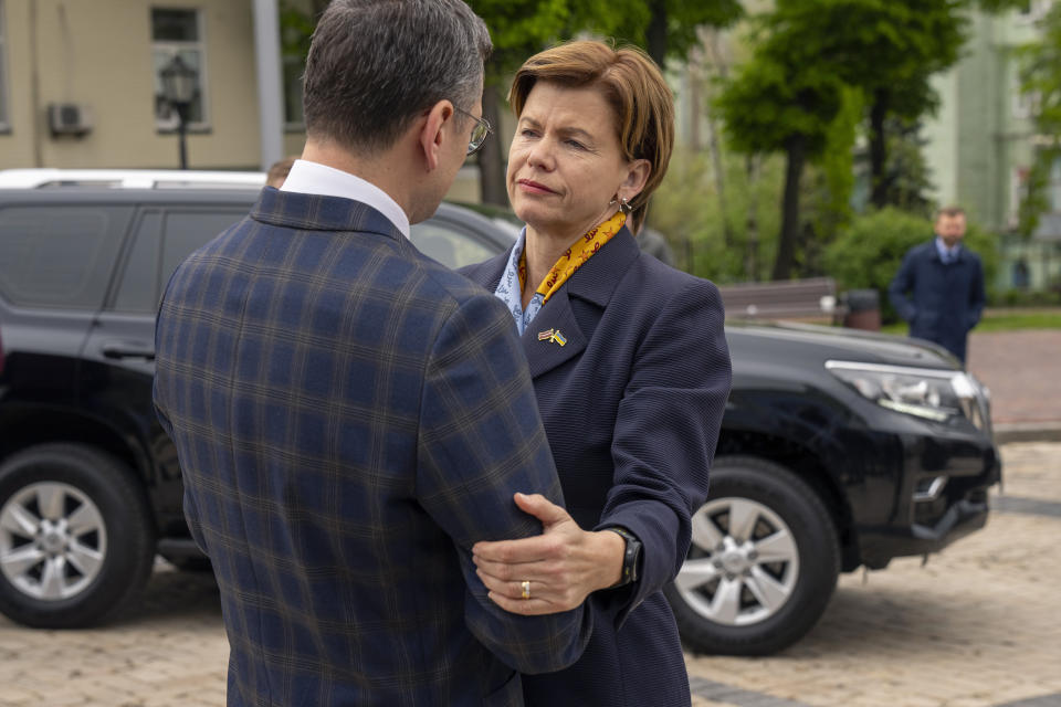 Latvia Foreign Minister Baiba Braze, right, is welcomed by her Ukrainian counterpart Dmytro Kuleba before placing flowers at a memorial wall of Ukrainian soldiers killed during the war at Saint Michael cathedral in Kyiv, Ukraine, Friday, April 26, 2024. Braze visited Kyiv on her first foreign trip to discuss aid for Ukraine, including a plan to build drones. (AP Photo/Francisco Seco)