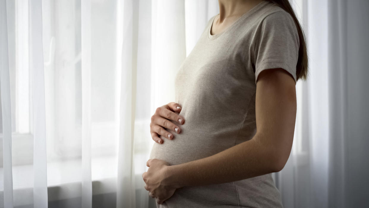 A pregnant woman by a window. (PHOTO: Getty Images)