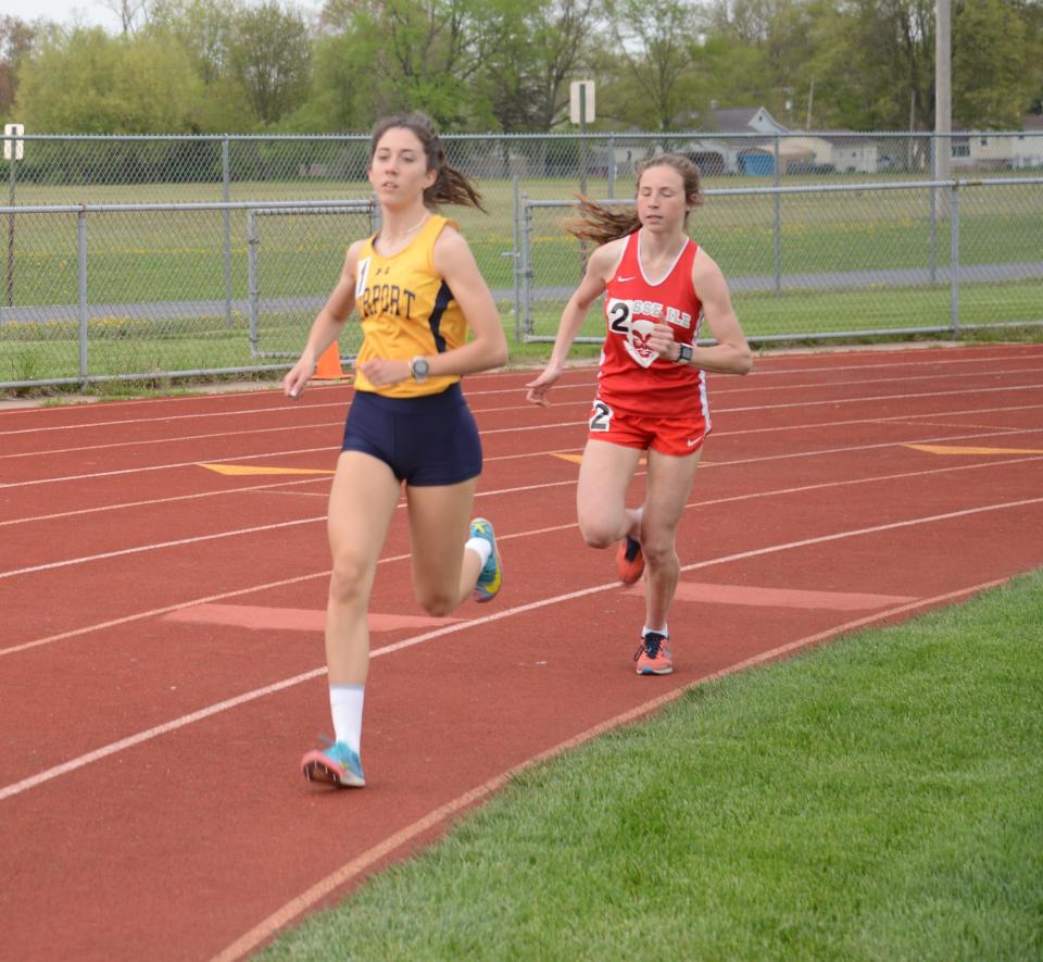 Airport's Mara Szuper makes a turn in the girls 800 meters with Grosse Ile’s Andie Fulmer right behind her earlier this season during a Huron League quad.