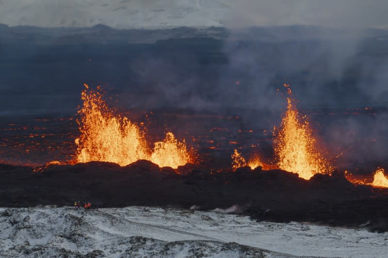 <cite>2023年12月19日，冰島雷克雅內斯半島活火山的熔岩噴泉。（美聯社）</cite>