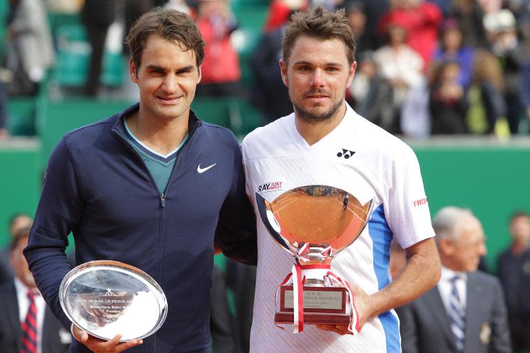 Switzerland's Stanislas Wawrinka (R) and Roger Federer pose with the trophies at the end of the final of the Monte Carlo ATP Masters Series Tournament, in Monaco, on April 20, 2014