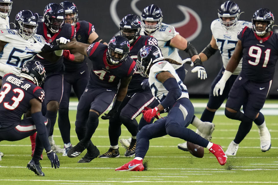 Tennessee Titans running back Derrick Henry, center, fumbles the ball as Houston Texans inside linebacker Zach Cunningham (41) defends during the second half of an NFL football game Sunday, Jan. 3, 2021, in Houston. The Texans recovered the fumble. (AP Photo/Sam Craft)