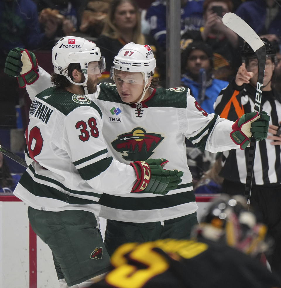 Minnesota Wild's Kirill Kaprizov (97) celebrates his second goal against the Vancouver Canucks with Ryan Hartman (38), during the second period of an NHL hockey game Thursday, March 2, 2023, in Vancouver, British Columbia. (Darryl Dyck/The Canadian Press via AP)
