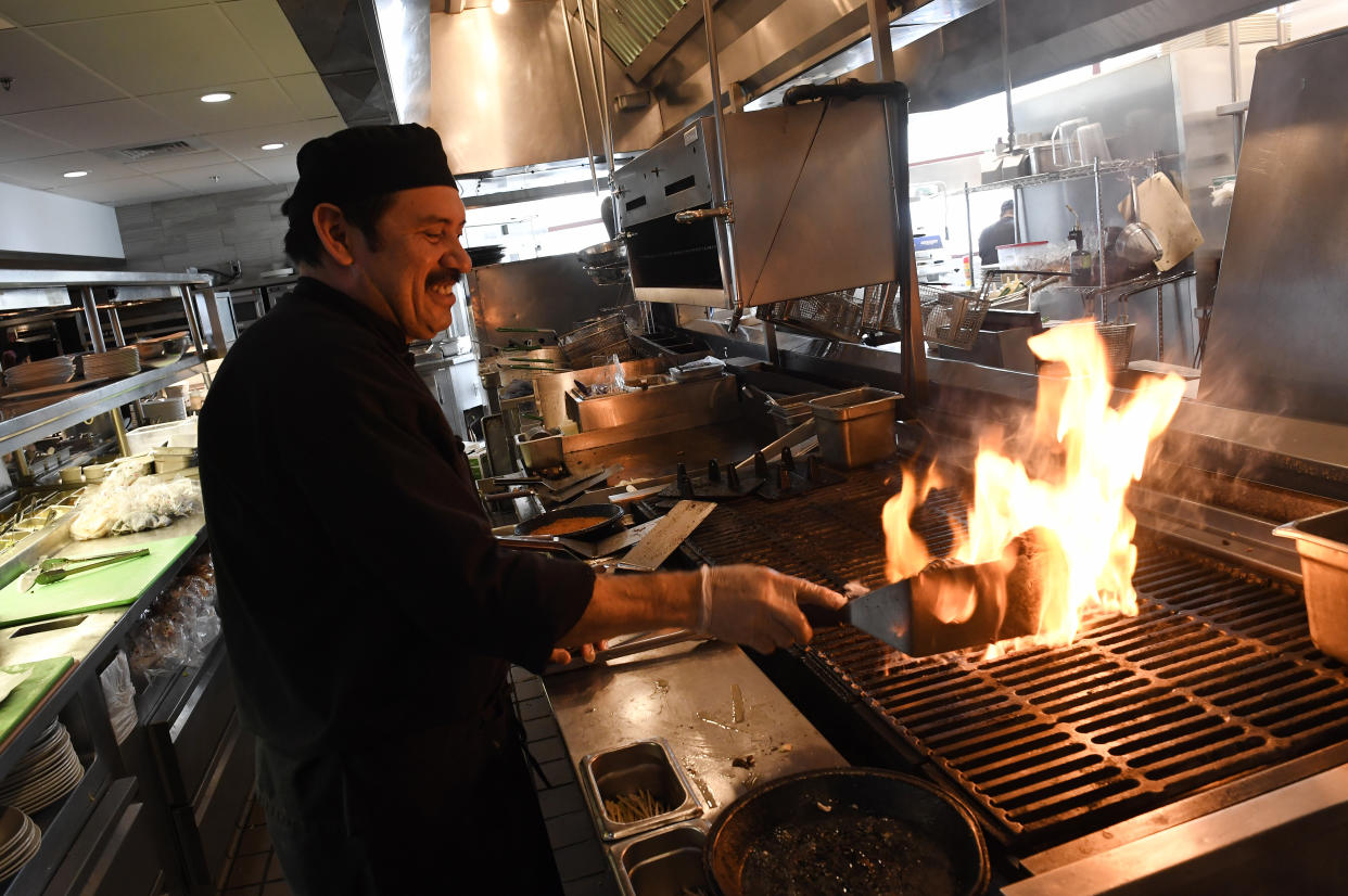 Cook Santiago Lopez flame broils meat for a hamburger during lunch at the Yard House in Lakewood, Colorado. A new Trump administration rule would allow employers to distribute servers’ tips to back-of-house employees (Helen H. Richardson/The Denver Post via Getty Images)
