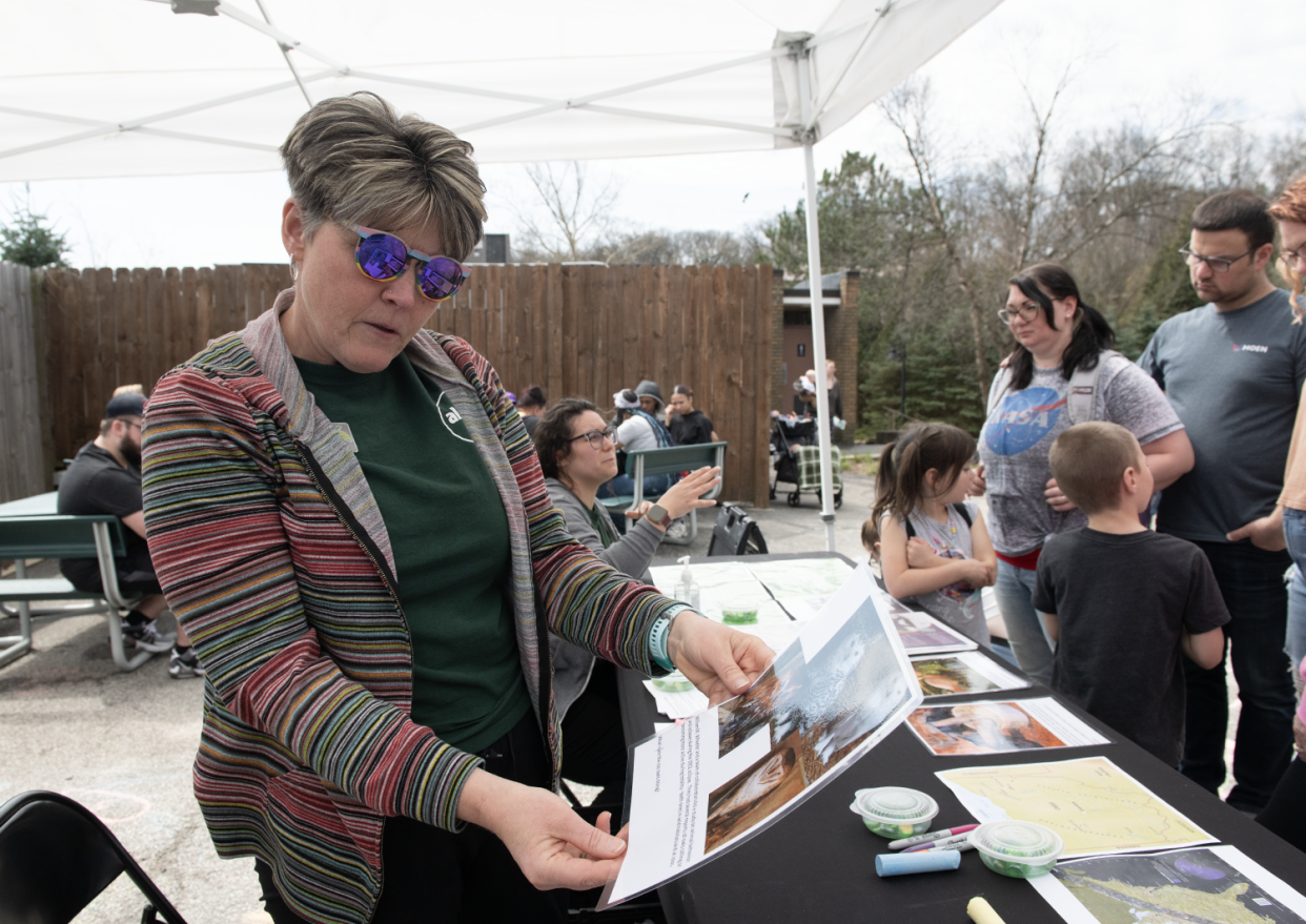 Angie Walsh, education mission specialist and Abby Sipos, education mission coordinator, tell Akron Zoo guests about the Eclipse Soundscapes Project on Monday.