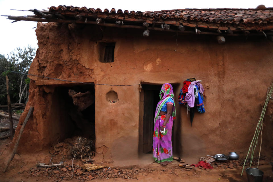A woman watches health workers leaving, standing in front of her house at Jamsoti village, Uttar Pradesh state, India, on June 8, 2021. India's vaccination efforts are being undermined by widespread hesitancy and fear of the jabs, fueled by misinformation and mistrust. That's especially true in rural India, where two-thirds of the country’s nearly 1.4 billion people live. (AP Photo/Rajesh Kumar Singh)