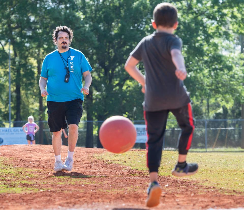 Counselor Thomas Owen pitches a kickball during the YMCA afterschool program at the Vickrey Community Center in Pensacola on Tuesday.