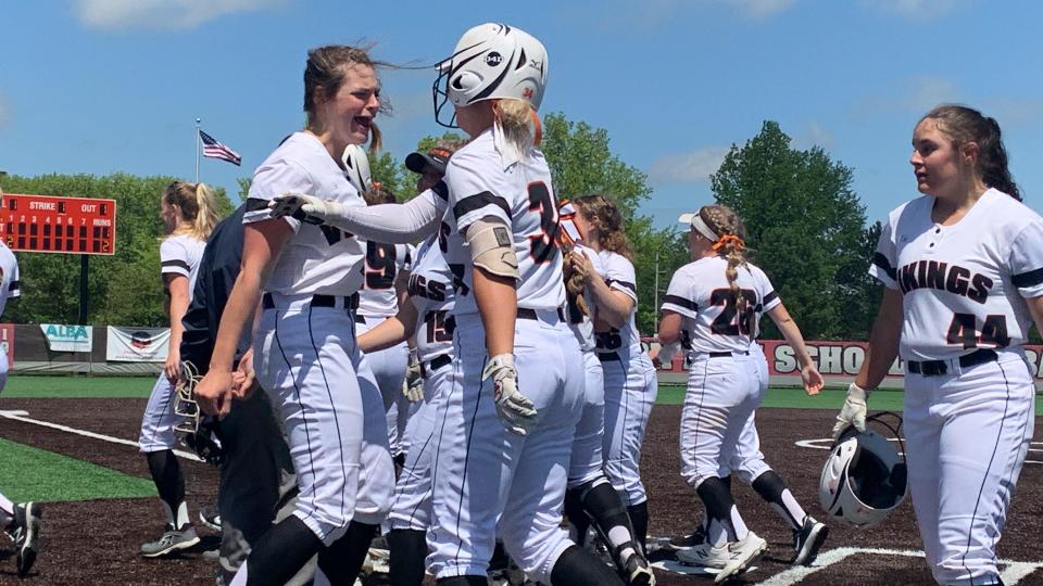 Sydnee Koosh (with helmet) celebrates with her Hoover softball teammates following her first-inning home run in a Division I district semifinal at Mentor on Monday. Hoover defeated Chardon 11-4.