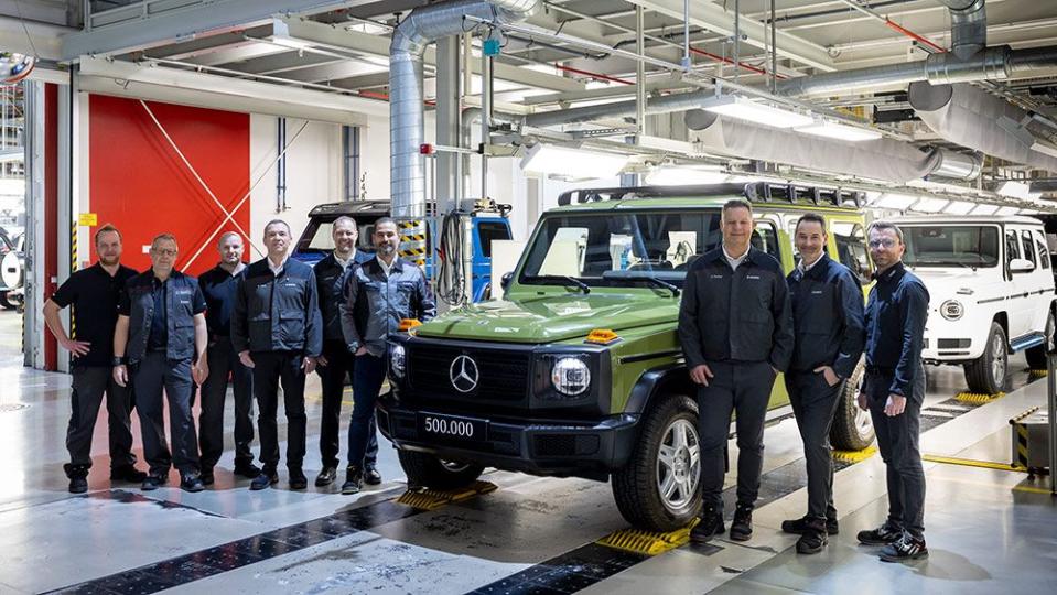 a group of men standing next to a green mercedes benz g class produced in graz austria