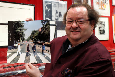 French Beatles specialist and collector Jacques Volcouve, one of the world's greatest living experts of the band, poses with an alternate picture for the cover of Abbey Road at Drouot auction house in Paris, March 16, 2017, a part of the 15,000 items going on sale on next March 18. REUTERS/Charles Platiau