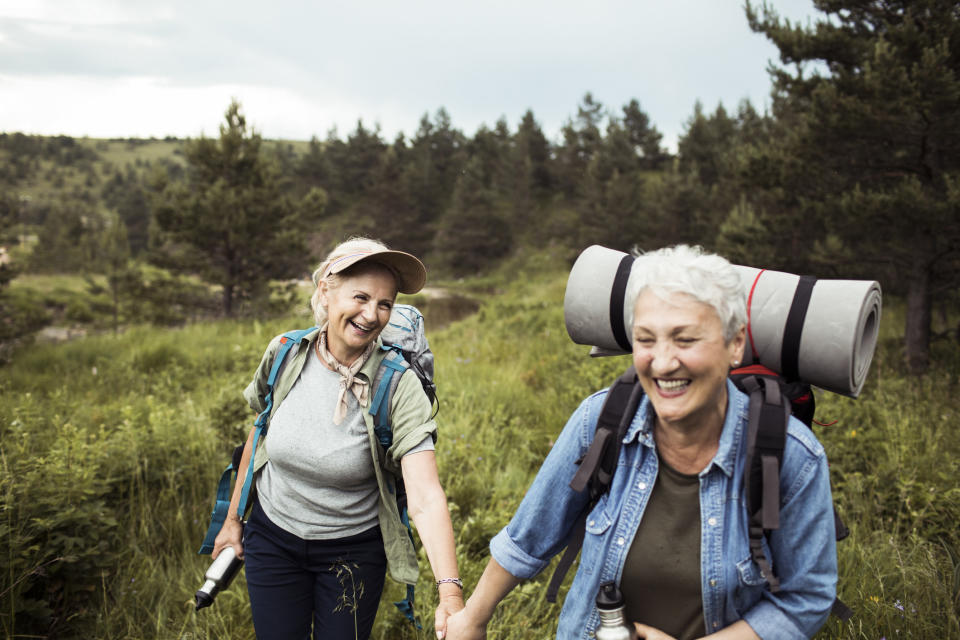 Two women holding hands on a hike