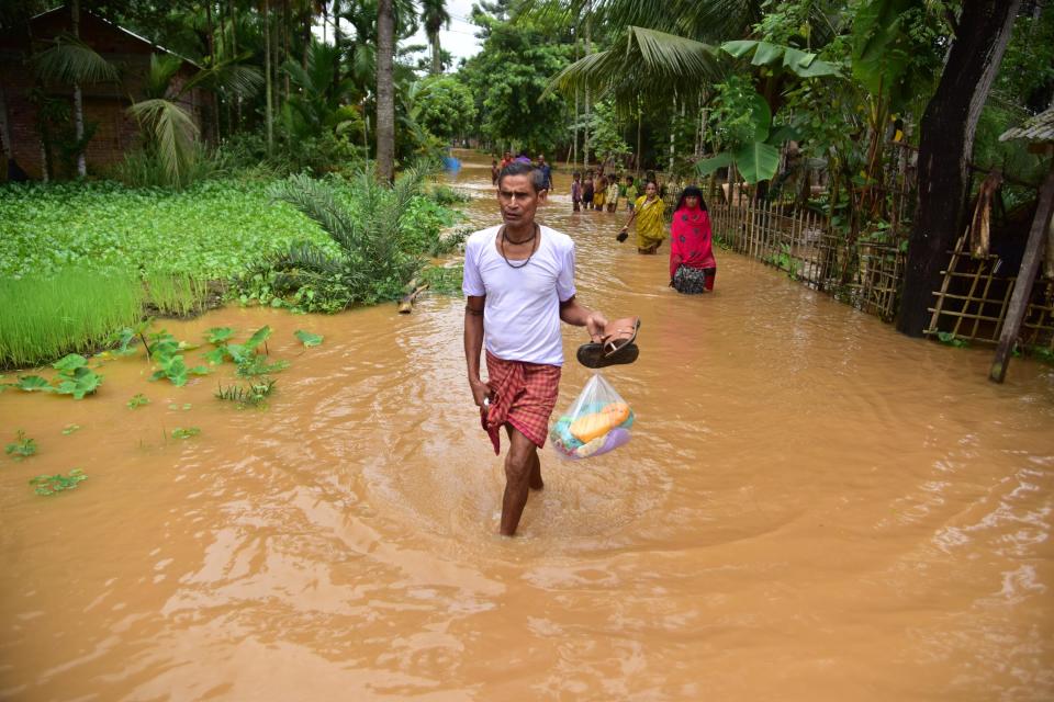 NAGAON,INDIA-JULY 22,2020 :Villagers wade through a flooded street at a flood affected area in Nagaon District of Assam ,India - PHOTOGRAPH BY Anuwar Ali Hazarika / Barcroft Studios / Future Publishing (Photo credit should read Anuwar Ali Hazarika/Barcroft Media via Getty Images)