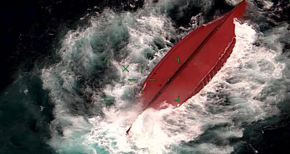 This image taken by camera mounted on aircraft and released by the 11th Regional Japan Coast Guard Headquarters shows a Chinese fishing boat capsized off Ishigaki Island, Okinawa prefecture, southern Japan on Tuesday, March 2, 2021. Japanese coast guard personnel were searching Wednesday for five crewmembers missing from the Chinese fishing boat that capsized near disputed waters. (The 11th Regional Japan Coast Guard Headquarters via AP)