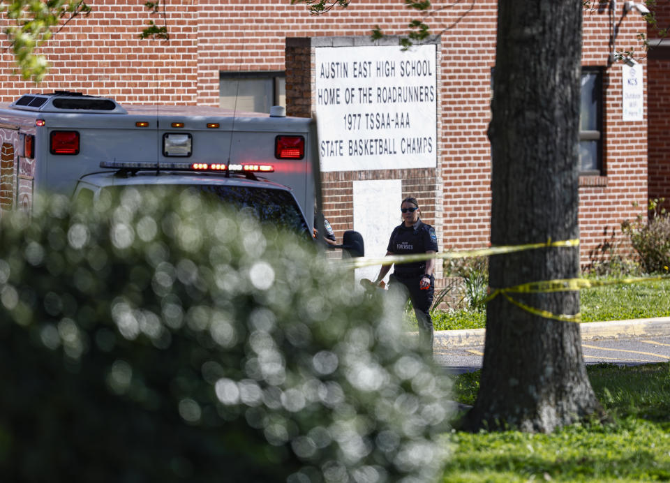 A member of the Knoxville police forensics team works the scene of a shooting at Austin-East Magnet High School in Knoxville, Tenn., Monday, April 12, 2021. (AP Photo/Wade Payne)