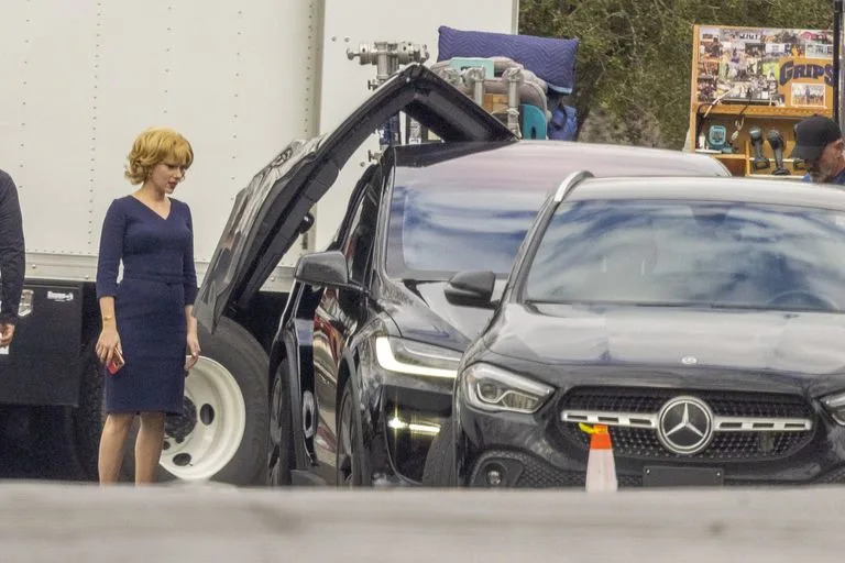 Scarlett Johansson espera pacientemente a que se abra la puerta de un Tesla en el set de 