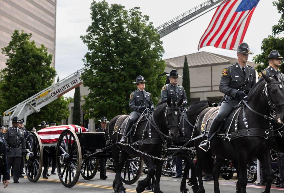 A horse-drawn carriage carries the body of officer Joshua Eyer to First Baptist Church on Friday, May 3, 2024. Officer Eyer was killed while serving a warrant in east Charlotte on Monday, April 29, 2024