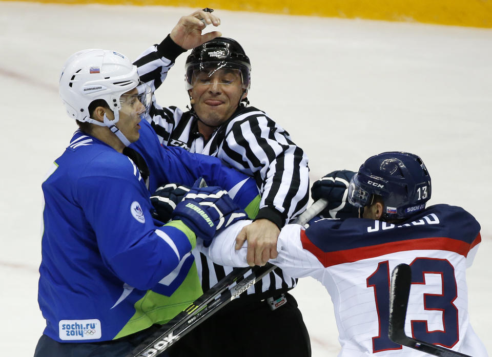 A linesman breaks up a fight between Slovenia defenseman Ziga Pavlin, left, and Slovakia forward Tomas Jurco period of a men's ice hockey game at the 2014 Winter Olympics, Saturday, Feb. 15, 2014, in Sochi, Russia. (AP Photo/Mark Humphrey)