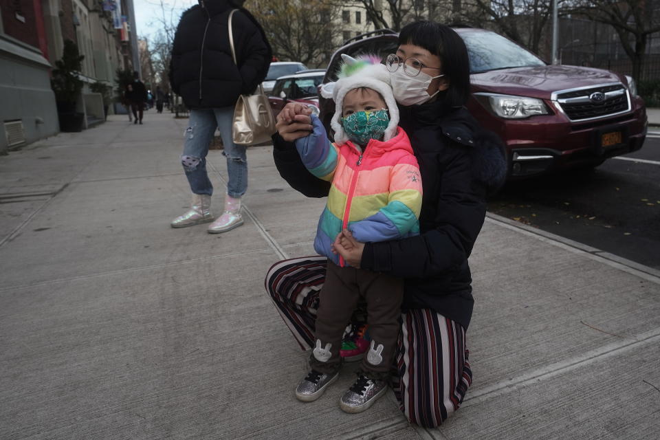 A parent and child wave to a sibling in the school yard at PS 361 on the first day of a return to class during the coronavirus disease (COVID-19) pandemic in the Manhattan borough of New York City, New York, U.S., December 7, 2020. REUTERS/Carlo Allegri