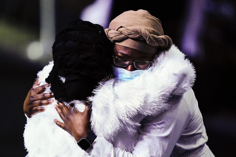 Mourners embrace during funeral services for the victims of a deadly row house fire, at Temple University in Philadelphia, Monday, Jan. 17, 2022. Officials say it was the city's deadliest single fire in at least a century. (AP Photo/Matt Rourke)