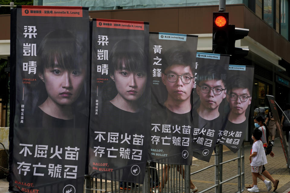 FILE - In this July 11, 2020, file photo, banners of a pro-democracy candidate Joshua Wong, wearing glasses, are displayed outside a subway station in Hong Kong, in an unofficial primary for pro-democracy candidates ahead of legislative elections. About 50 Hong Kong pro-democracy figures were arrested by police on Wednesday, Jan. 6, 2021 under a national security law, following their involvement in an unofficial primary election last year held to increase their chances of controlling the legislature, according to local media reports. (AP Photo/Vincent Yu,File)