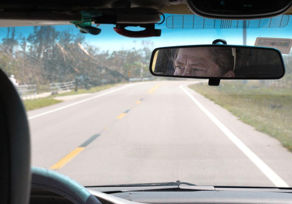 Christine Wright views damage from Hurricane Ian as she drives on Pine Island, Fla., on Monday.