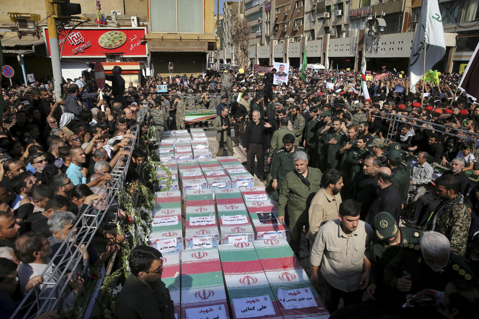 Flag-draped caskets of those who died in Saturday's terror attack on a military parade are laid out during a mass funeral, in the southwestern city of Ahvaz, Iran, Monday, Sept. 24, 2018. Thousands of mourners gathered at the Sarallah Mosque on Ahvaz's Taleghani junction, carrying caskets in the sweltering heat. (AP Photo/Ebrahim Noroozi)