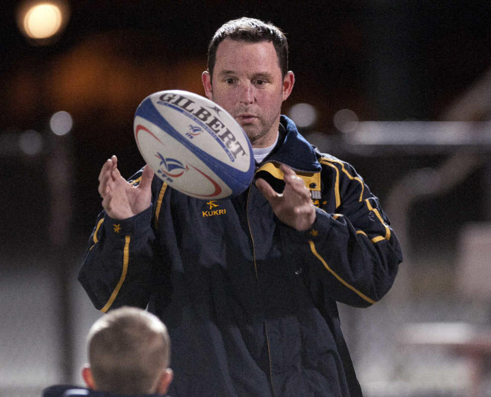 Jamie Gniadek, the former president of the Worcester Rugby Football Club, tosses a ball with his son, Ben, while his team practiced at Worcester State in 2012. On Wednesday, Ben practiced rugby with the WPS Wildcats rugby team.